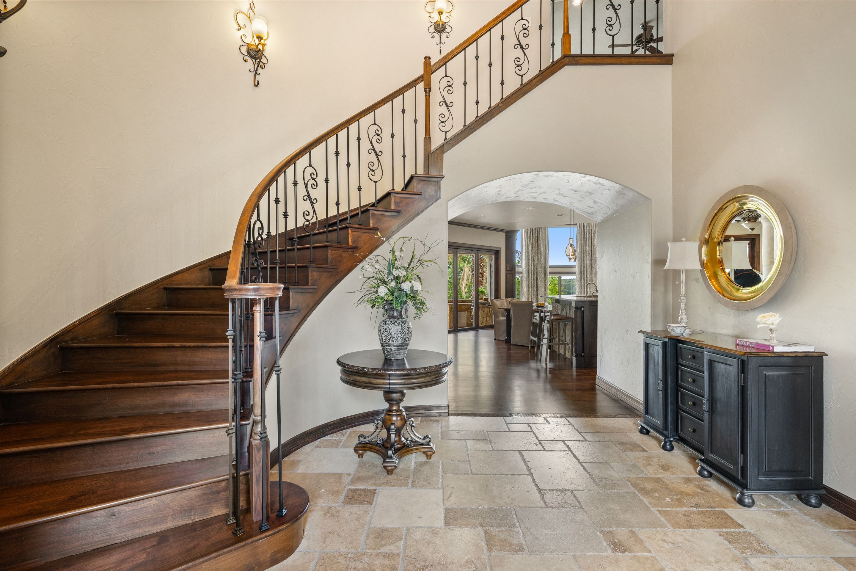Curved staircase and entry hall at Lakehaven with plaster walls and iron railing