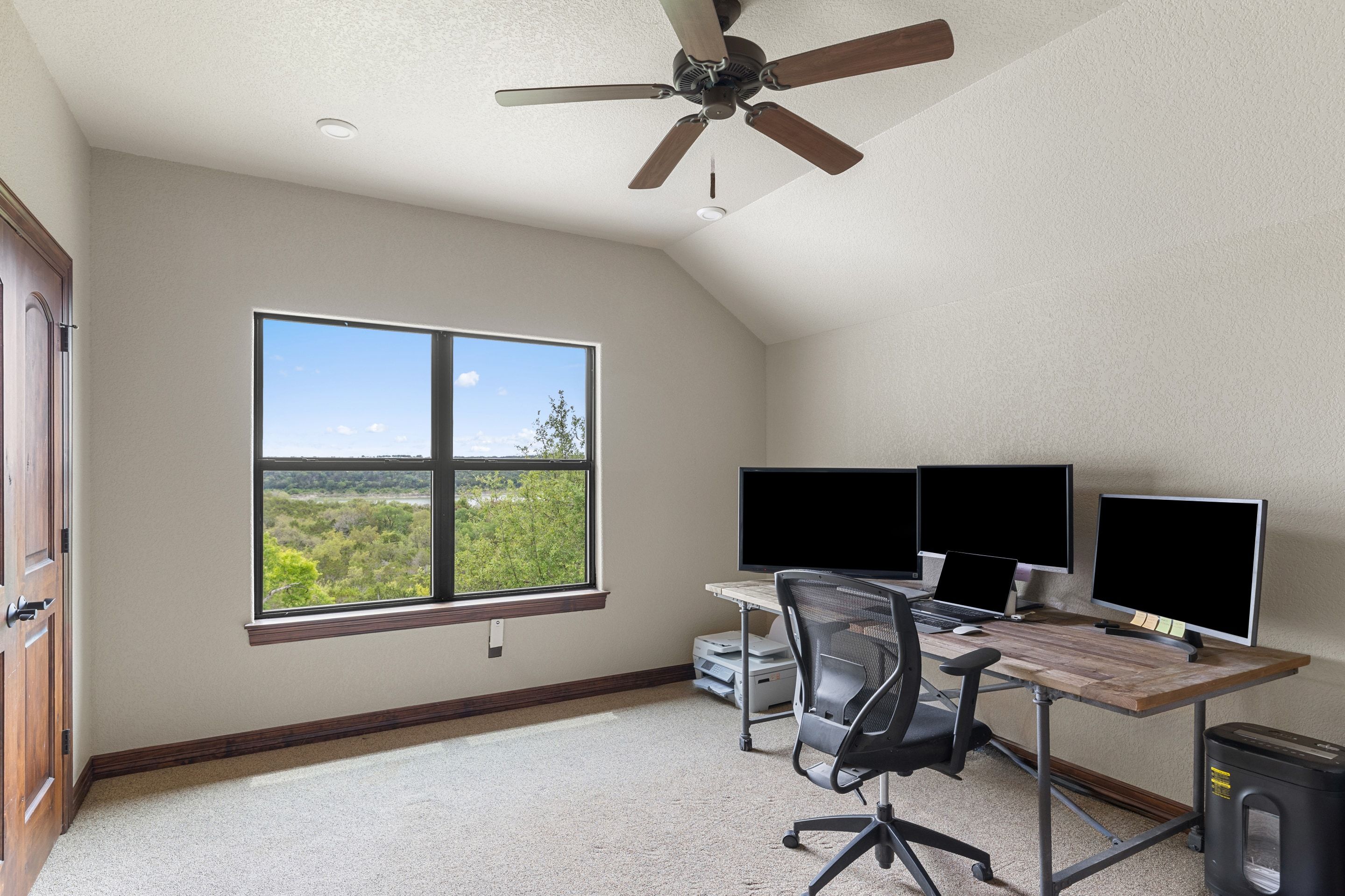 Study at Lakehaven with a desk, built-ins, and wide lake-facing windows