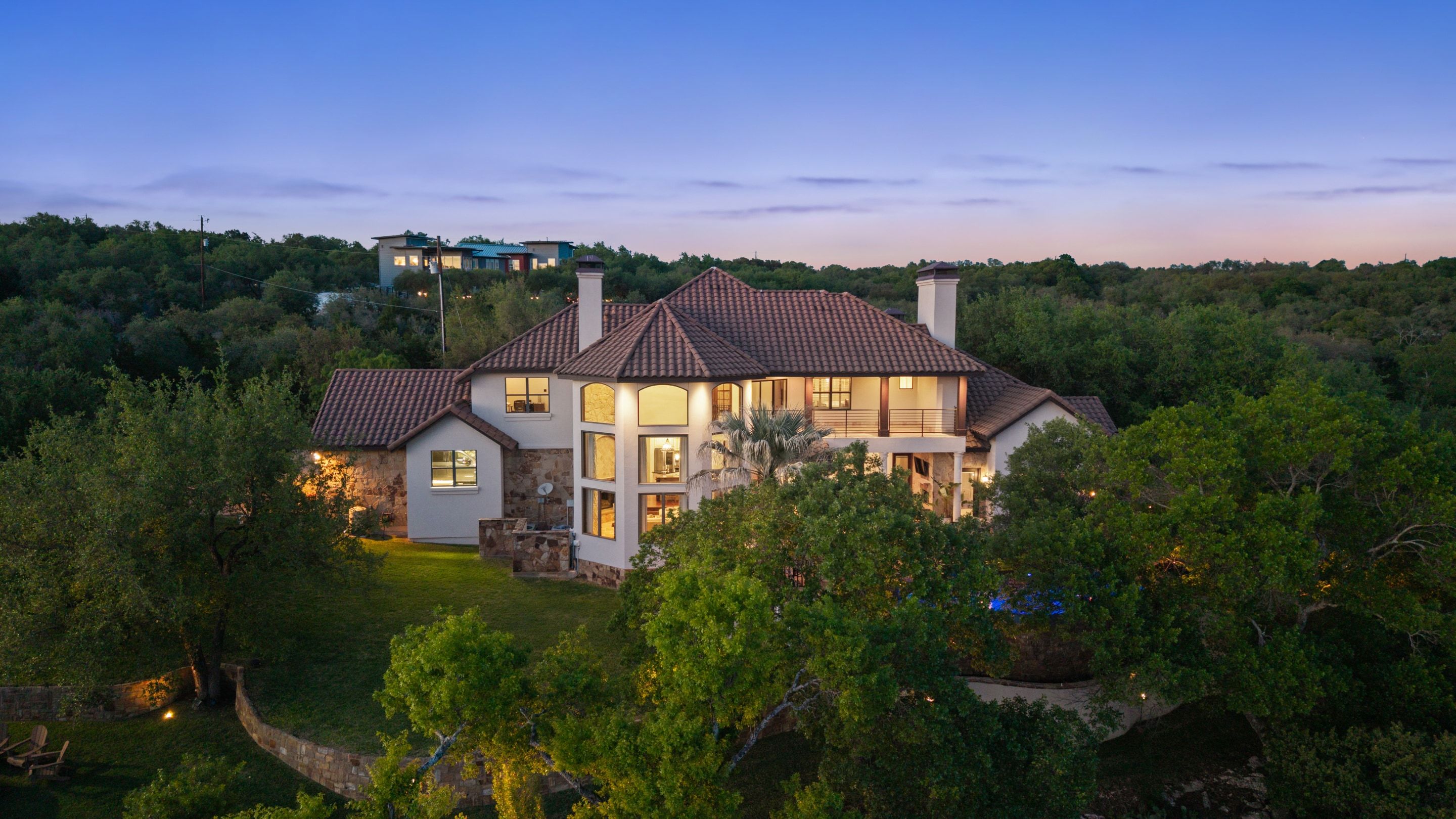 Rear aerial of Lakehaven at twilight showing the residence above the surrounding tree canopy