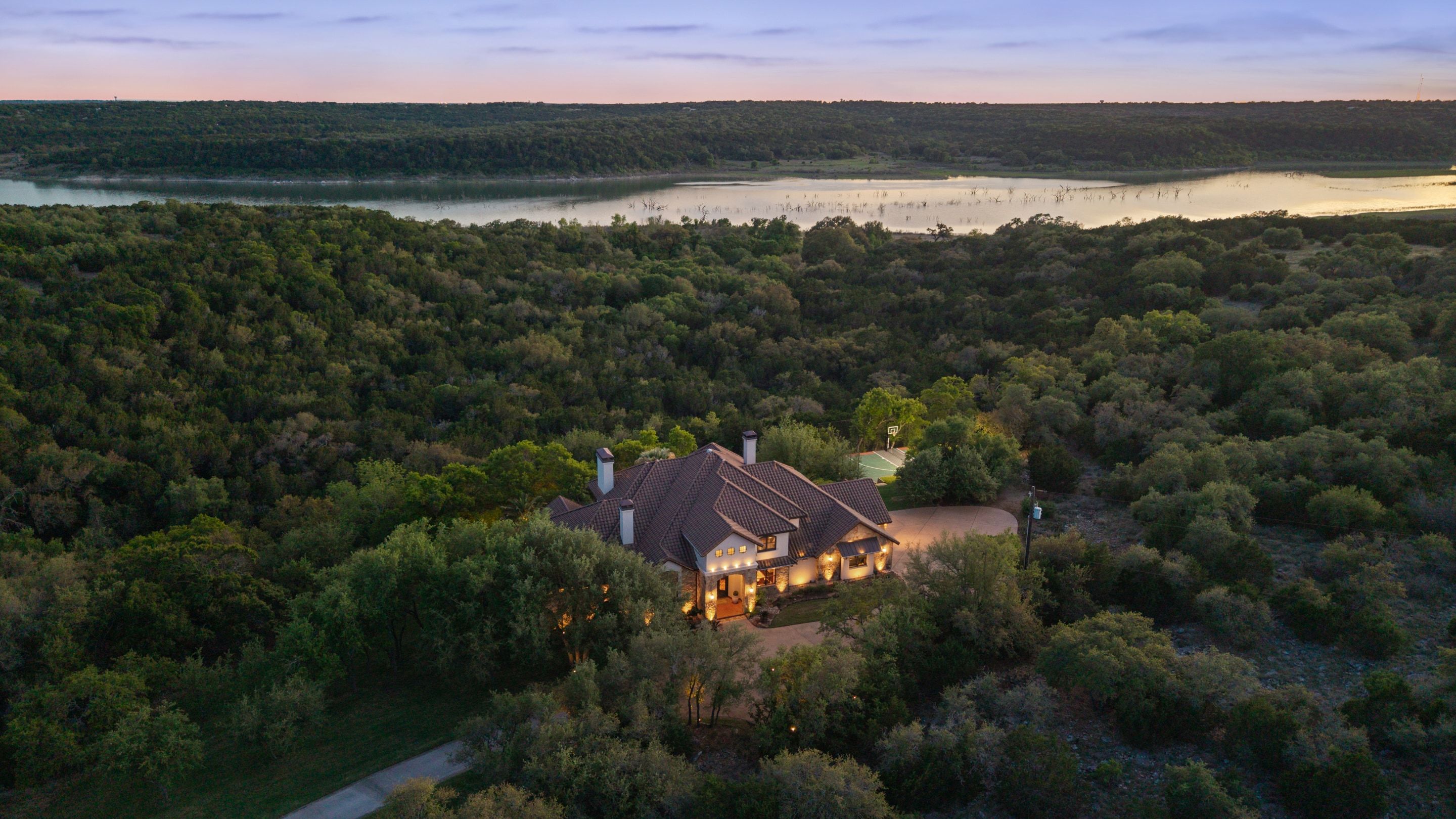 Lakehaven aerial at dusk with the residence set below panoramic Lake Georgetown views